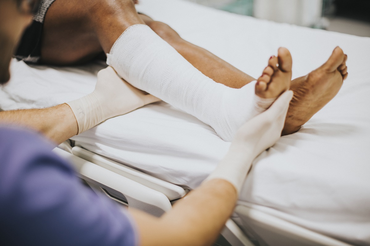 Foot Drop Doctor assisting a patient by pushing up a drop foot during a physical therapy session.